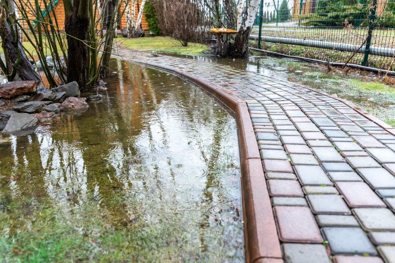 flooded path in yard with brick walkway